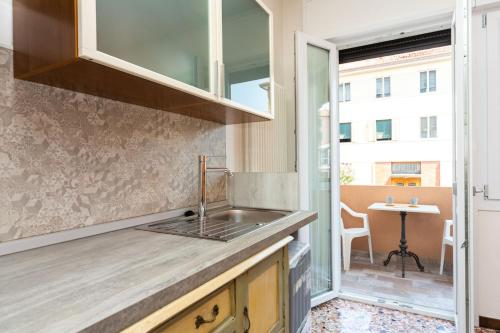 a kitchen with a sink and a counter with a table at Monti Guesthouse in Mestre