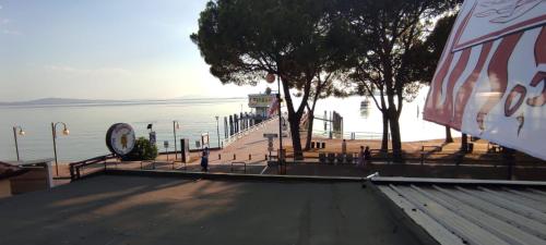 a view of a pier with a boat in the water at The View - Sunset & Relax - Suite - Appartamenti Vista Lago in Passignano sul Trasimeno