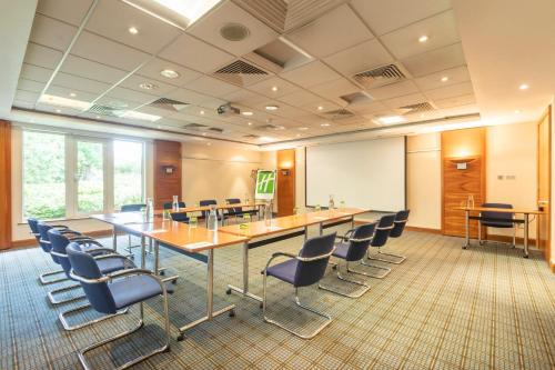 a conference room with a long table and chairs at Holiday Inn Guildford by IHG in Guildford