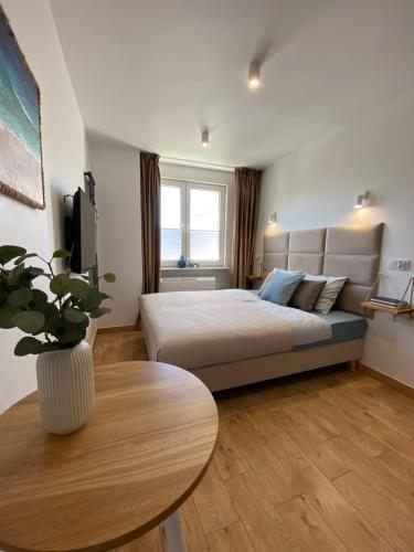 a bedroom with a bed and a table in it at La Playa Apartments in Hel