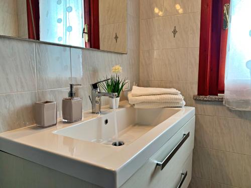 een badkamer met een witte wastafel en een spiegel bij DomoMea - Angela in Quartu SantʼElena