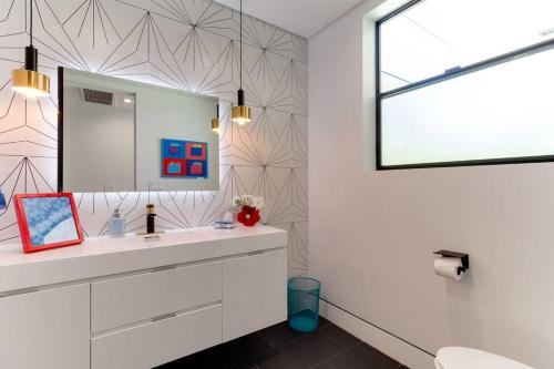 a bathroom with a sink and a mirror at Posh Luxury Modern Home with Pool Spa and Rooftop Deck in Encino
