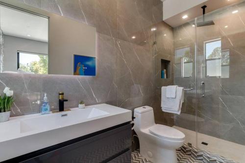 a bathroom with a sink and a toilet and a shower at Posh Luxury Modern Home with Pool Spa and Rooftop Deck in Encino