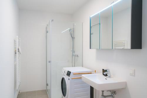 a white bathroom with a sink and a shower at Vienna Residence, Marina Tower - Danube in Vienna