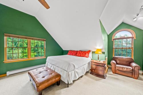 a bedroom with green walls and a bed and a chair at The Barn on Bartman in Johnsburg