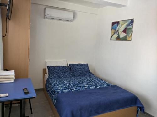 Vila Grozdanoski في Konjsko: غرفة نوم صغيرة بسرير ازرق وطاولة