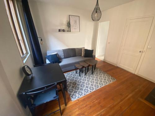 un salon avec un canapé et une table dans l'établissement Magnifique T2 typique normand - 103, à Rouen