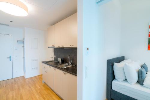 a kitchen with a couch and a sink in a room at Vienna Residence, Marina Tower - Danube in Vienna