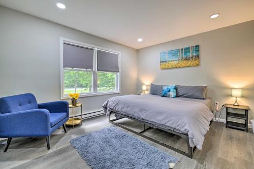 a bedroom with a bed and a blue chair at Furnished Deck and Lake Access Poconos Place! in Tobyhanna