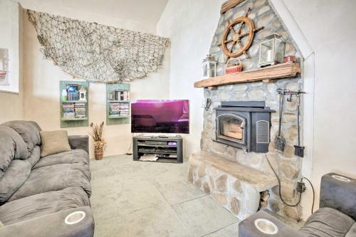 a living room with a stone fireplace and a tv at Oceanside Getaway with Beach Access and Home Gym! in Coos Bay