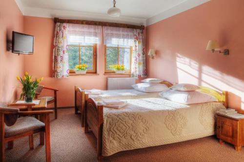 a bedroom with two beds and a table and chairs at Chata Cyborga in Stronie Śląskie