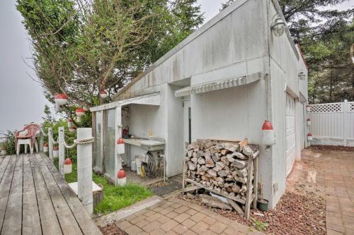 a white building with a pile of fire wood at Oceanside Getaway with Beach Access and Home Gym! in Coos Bay