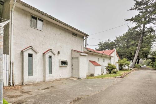 a white building with a parking lot next to a street at Oceanside Getaway with Beach Access and Home Gym! in Coos Bay