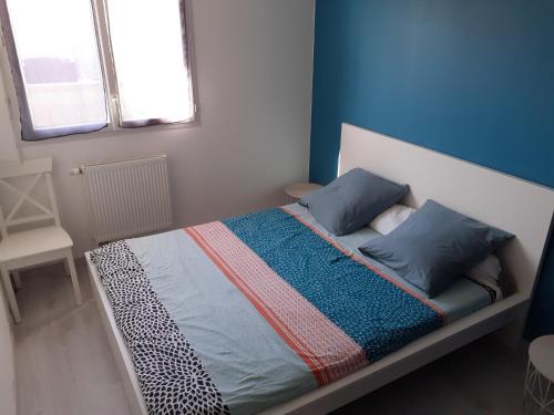 niewielka sypialnia z łóżkiem z niebieskimi ścianami w obiekcie Maison familiale entre Dinard-St Malo-Dinan. w mieście Pleslin-Trigavou