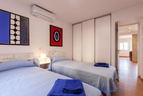 een slaapkamer met 2 bedden en een kamer bij Blick auf Atalaya in Port de Pollença