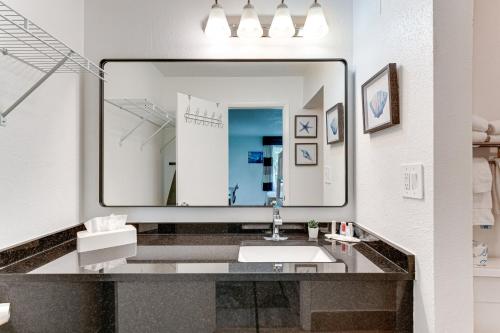 a bathroom with a sink and a large mirror at Sarasota Cay Club #612 - Heated Pool, Bunk Beds, Huge TV, Tiki Bar, More! in Sarasota