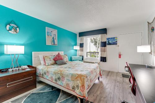 a bedroom with a bed and a blue wall at Sarasota Cay Club #612 - Heated Pool, Bunk Beds, Huge TV, Tiki Bar, More! in Sarasota