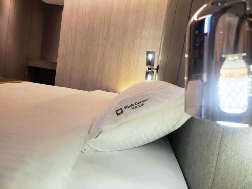 a hotel room with a towel on a bed at Hualien Pink Corner Hotel in Hualien City