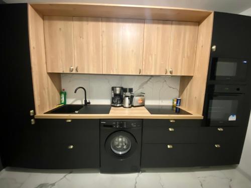 une cuisine avec un évier et une machine à laver dans l'établissement Appartement spacieux pour 6 - Rive gauche - parking -093, à Rouen