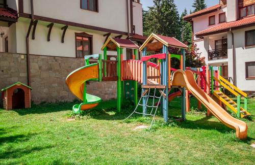 a playground with a slide in the grass at Stand'Art - апартамент , Смолянски езера in Smolyan