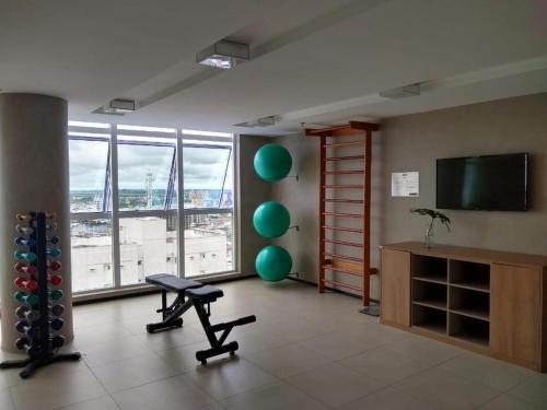 a living room with a large window and a flat screen tv at Flat Completo no Soho - Wi-Fi e NF in Campos dos Goytacazes
