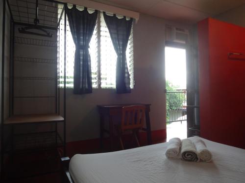 a bedroom with a bed with towels on it at Hostal Harvest House in León