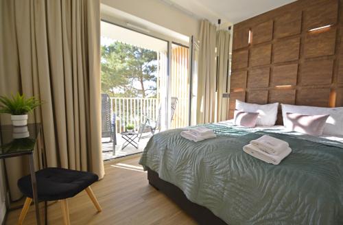 a bedroom with a bed with two towels on it at Apartamenty Bryza-Baltycki - Apartamenty przy plaży z parkingiem in Świnoujście
