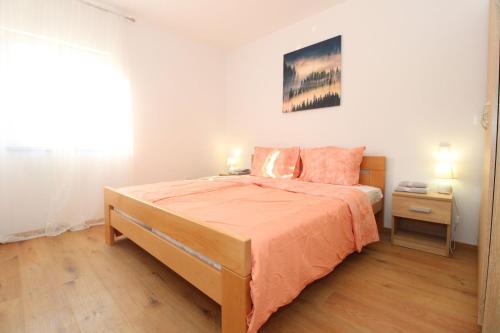 1 dormitorio con cama con sábanas de color naranja y ventana en Kuča za odmor Pag Sv.Marko, en Pag