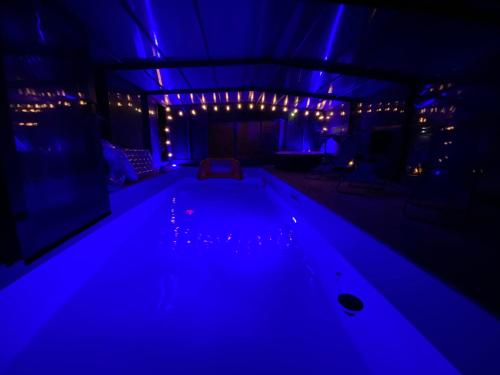 a swimming pool in a room lit up with blue lights at Gîte du Silo Loft atypique ,Tournesol , spa&piscine couverte in Toucy