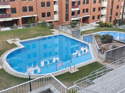 einen Blick über einen großen Pool in einem Gebäude in der Unterkunft Precioso apartamento con terraza, pistas de padel y piscinas in Castro-Urdiales