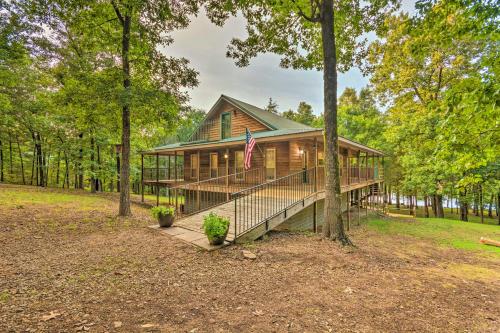 a log cabin in the woods with a flag at Lakefront Hideaway in Scranton Spacious Deck in Scranton