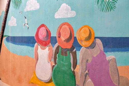 a painting of four people sitting on the beach at Kas di Bientu at Windsock Beach in Kralendijk