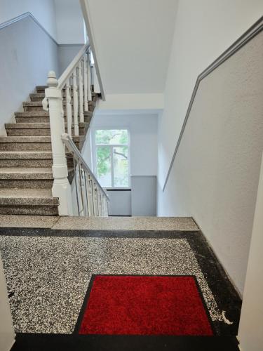 a stairway with a red rug on the floor at Apartment OTTO I - Erfurt Zentrum in Erfurt