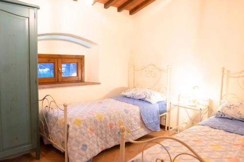 um quarto com 2 camas e uma janela em Casa alle Monache em Gambassi Terme