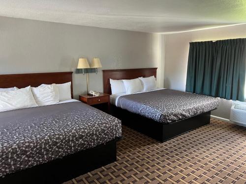 Habitación de hotel con 2 camas y ventana en Budget Inn, en Tallahassee