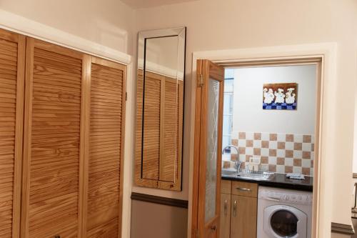 a kitchen with a washer and dryer in a room at 206mm Highgate Apartment in London