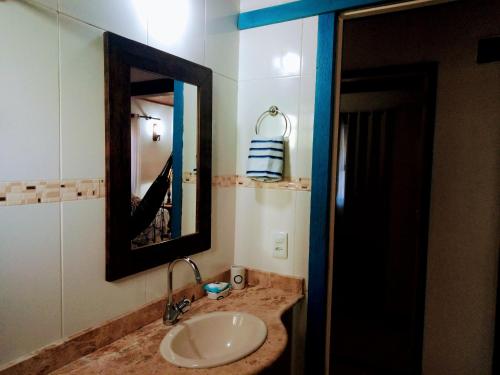 a bathroom with a sink and a mirror at Casa no Centro de Búzios in Búzios