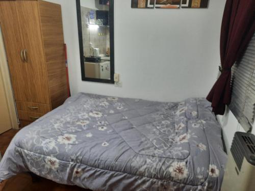 uma cama com um edredão azul num quarto em Complejo las Palmeras em Godoy Cruz