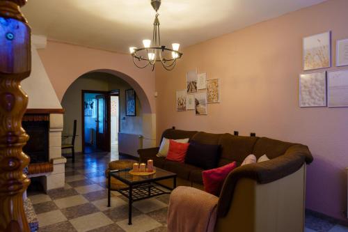 sala de estar con sofá y chimenea en Casa Rural Campoamor, en Carboneras de Guadazaón