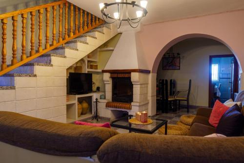 a living room with a staircase and a fireplace at Casa Rural Campoamor in Carboneras de Guadazaón