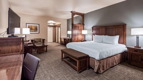 a hotel room with a bed and a desk and a television at Best Western Plus High Country Inn in Ogden