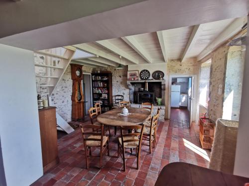 une cuisine et une salle à manger avec une table et des chaises dans l'établissement Maison de campagne isolée pour famille, à Ternant