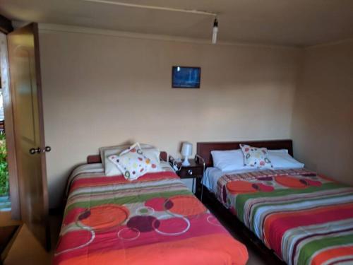 a bedroom with two beds and a tv on the wall at La Querencia in Cuenca