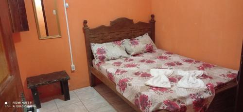a bedroom with a bed with shoes on it at Pousada Labarca in Cachoeira