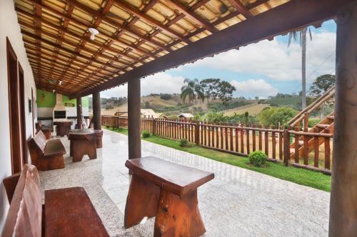 porche con bancos de madera y balcón con vistas en Paraíso Rural, en São Thomé das Letras