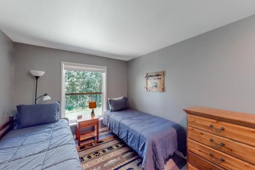 a bedroom with two beds and a dresser and a window at Getaway on Mariposa in Hailey