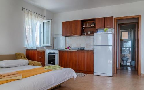 a kitchen with a white refrigerator and wooden cabinets at Apartment Sveta Nedilja 14086b in Jelsa