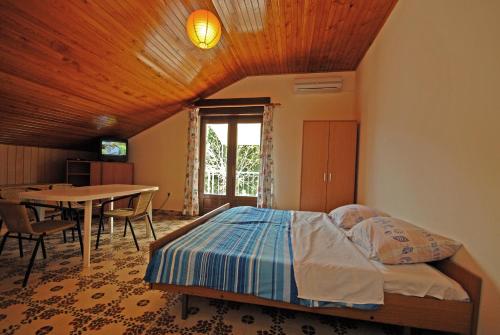 sypialnia z łóżkiem i stołem jadalnym w obiekcie Apartments and rooms with a swimming pool Kali, Ugljan - 14083 w mieście Kali