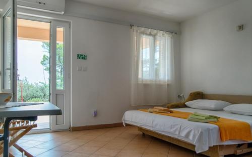 een slaapkamer met een bed en een groot raam bij Apartments with a parking space Sveta Nedilja, Hvar - 14086 in Jelsa