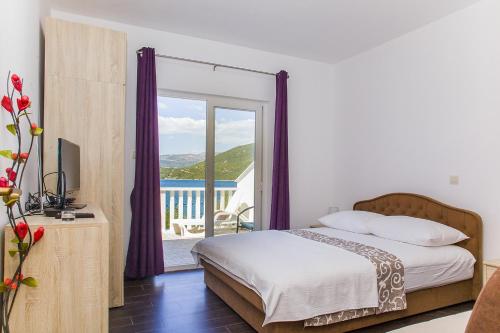 una camera con letto e balcone di Apartments by the sea Zuronja, Peljesac - 14095 a Putniković